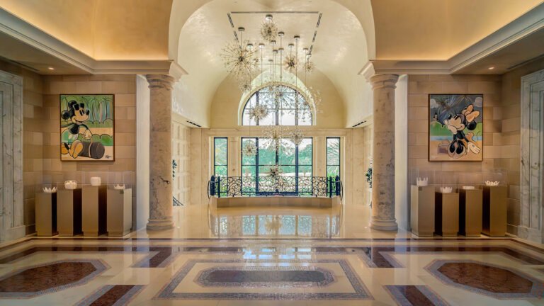 Marble lobby of Four Seasons Resort Orlando with starburst chandeliers and Mickey and Minnie Mouse pop-art paintings