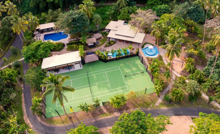 Aerial view of the Kids Bula Club at Jean-Michel Cousteau Resort Fiji, showing its two swimming pools, tennis court and playground