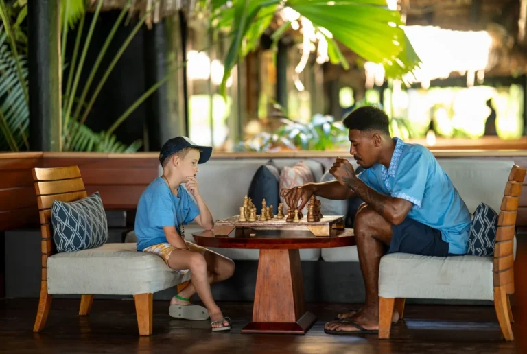 A child plays chess with his Fijian buddy from the Kids Bula Club at Jean-Michel Cousteau Resort Fiji