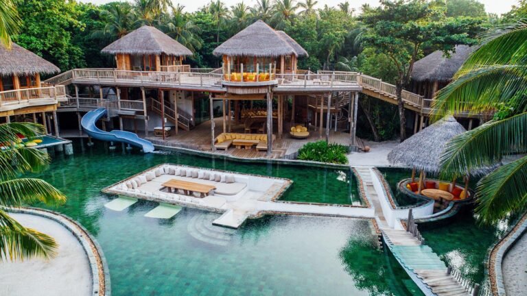 Aerial drone view of Soneva Fushi overwater villas and Kunfunadhoo island, Baa Atoll