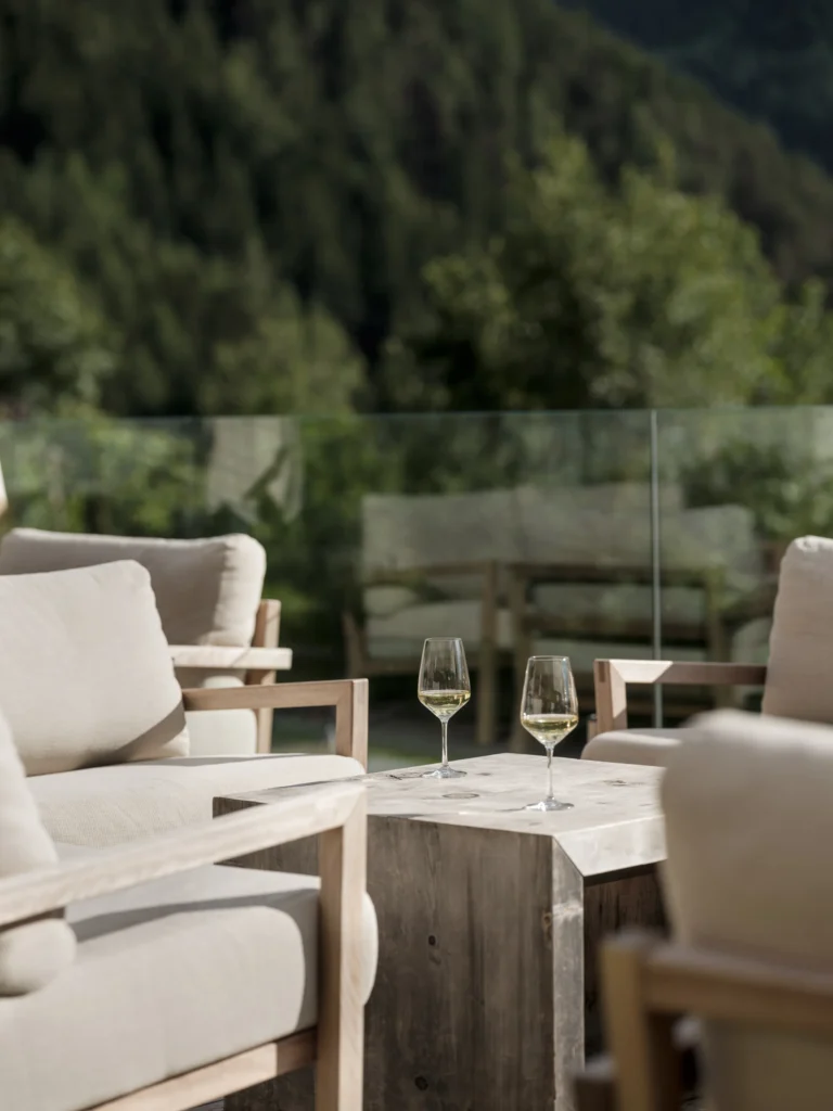 A generous South Tyrolean breakfast spread at Sonnwies with fresh breads, regional cheeses, house-made preserves and sliced Alpine speck arranged on a long buffet table.