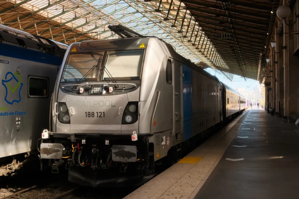 European Sleeper night train with its blue and white coaches waiting at a platform in Paris Nord station, ready to depart for Berlin.