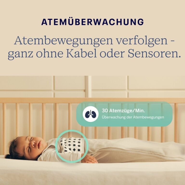 Parent in bed checking the Nanit app live cot view on a phone, with a cry alert notification