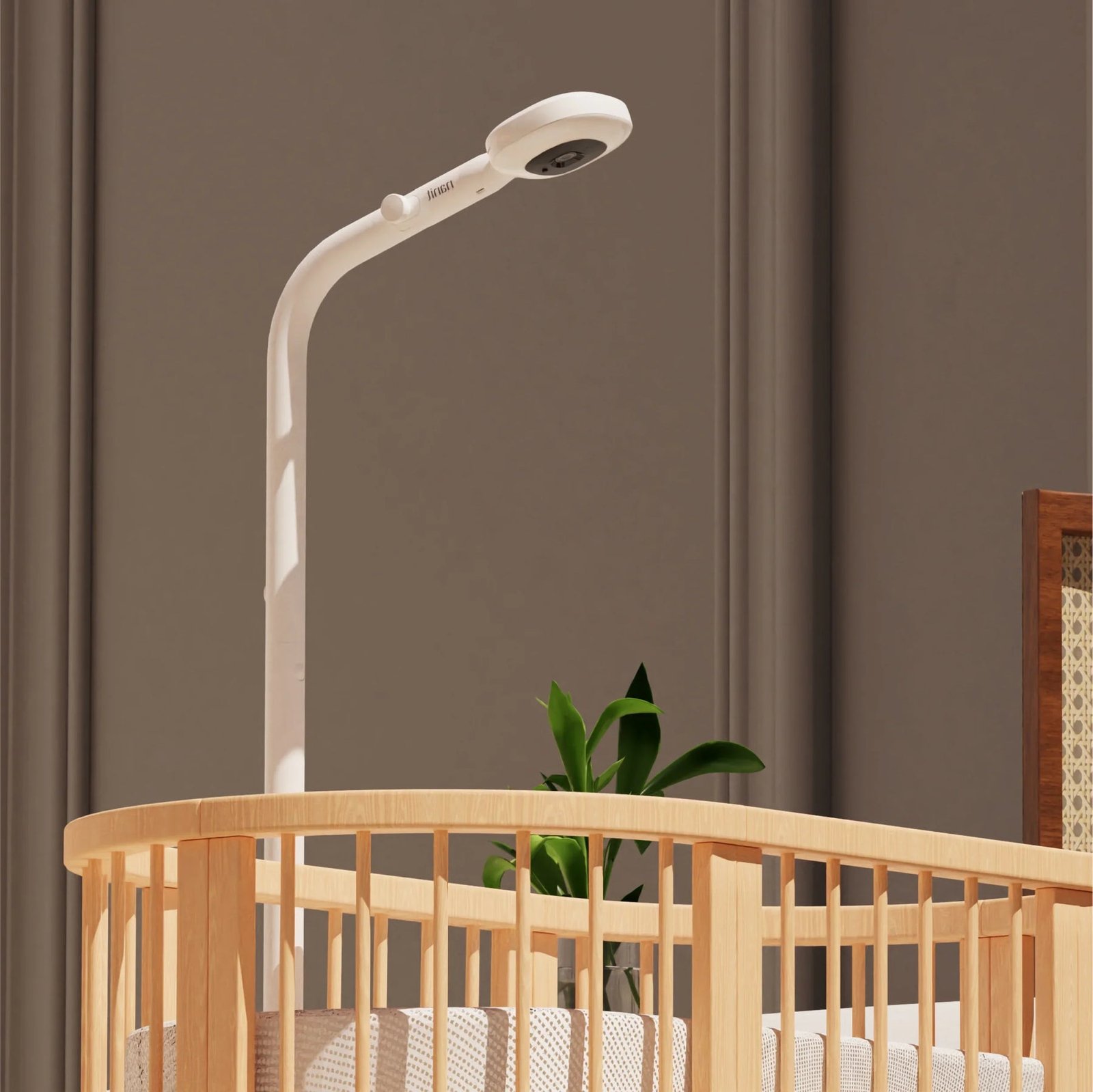 Nanit Pro baby monitor camera on its floor stand positioned over a cot for an overhead view