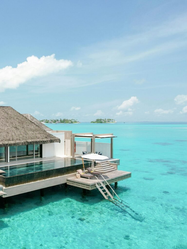 Bedroom and living area of an overwater Horizon Villa at Cheval Blanc Randheli