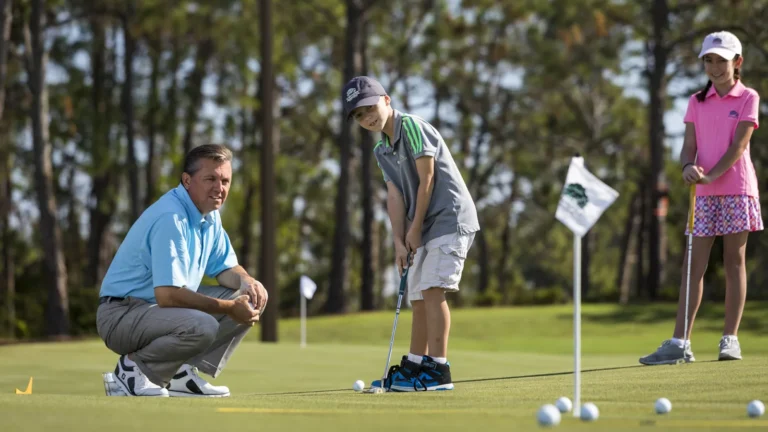 A father and two children practicing on the putting green at the Tranquilo Golf Club at Four Seasons Resort Orlando