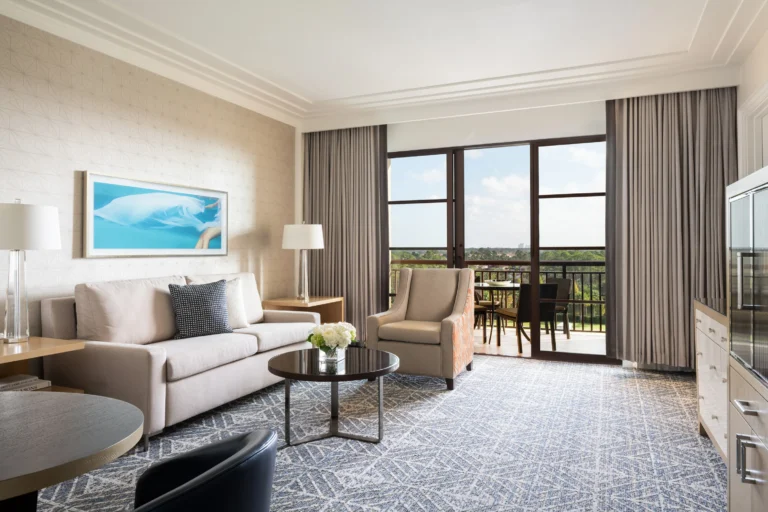 Suite living room at Four Seasons Resort Orlando with a sofa, armchairs and balcony access