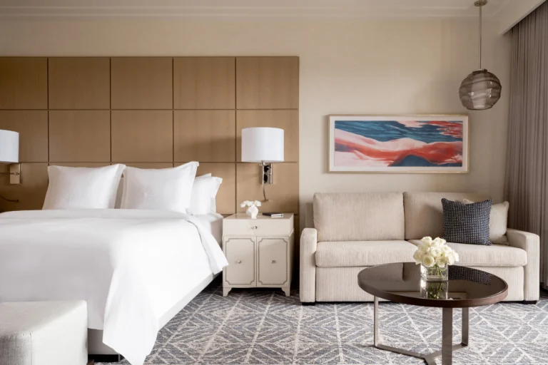 King bed guest room at Four Seasons Resort Orlando with a private balcony overlooking the resort's woodland and lake