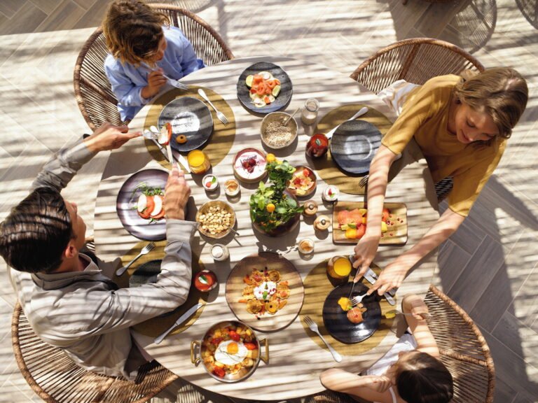 Family with children dining together at the Oliva restaurant at an Ikos resort