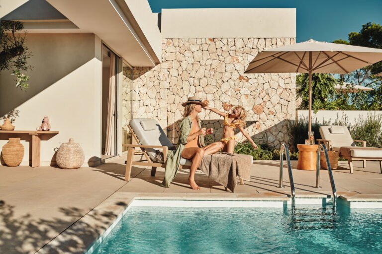 Mother and daughter relaxing together by the pool at an Ikos resort
