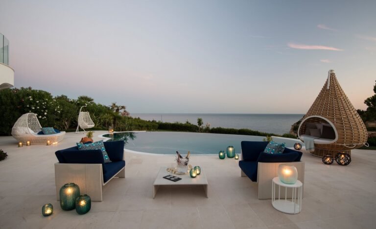 Pool with cabana and daybeds against stone walls at Vila Vita Parc Vila Praia