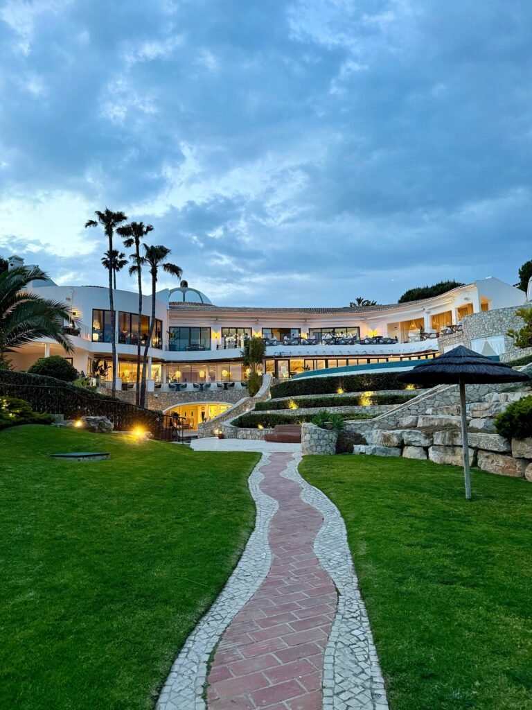Vila Vita Parc main resort building illuminated at dusk above landscaped gardens