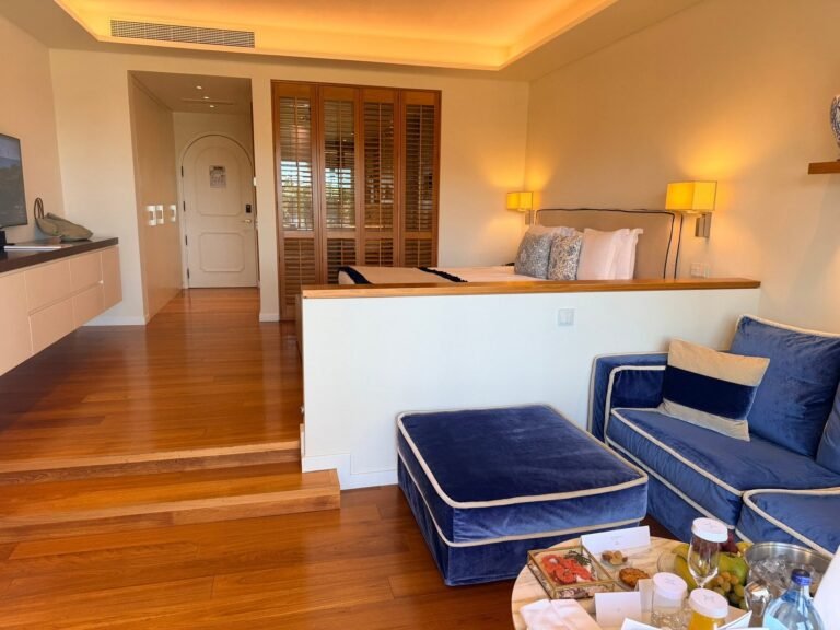 Junior suite at Vila Vita Parc with blue sofa, king bed and wood floors