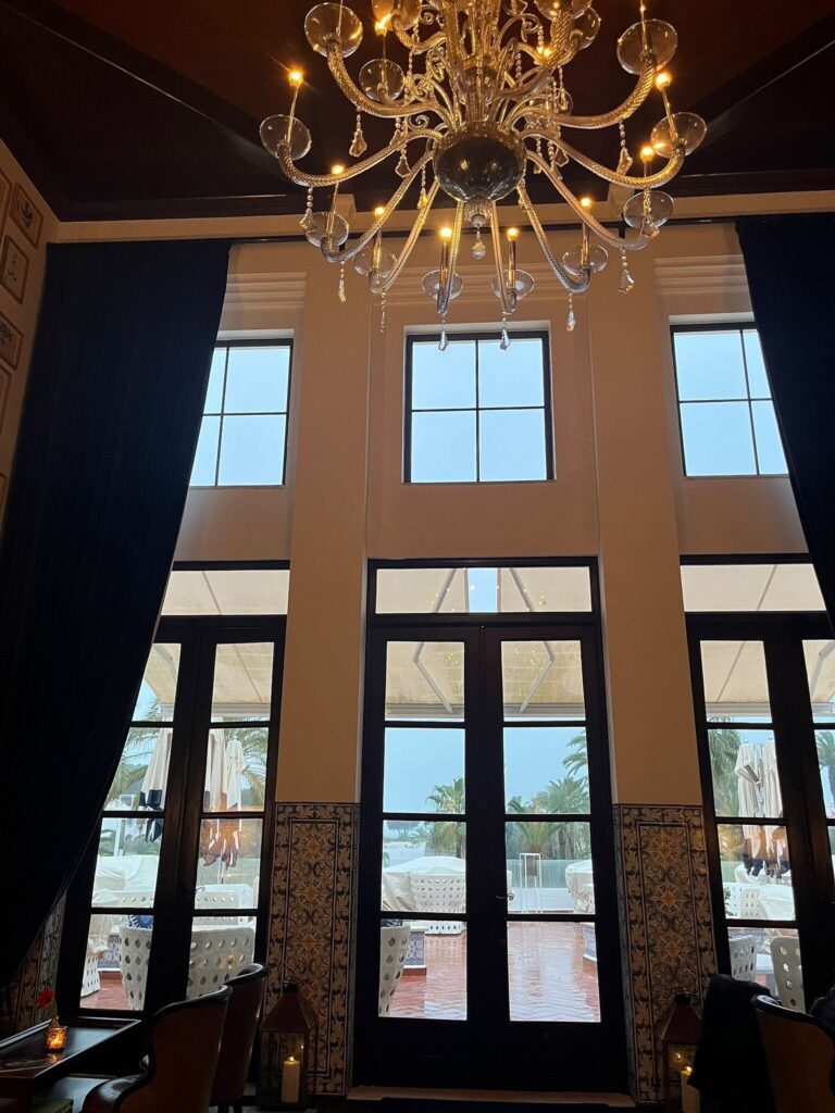 Restaurant interior with chandelier and sea-view windows at Vila Vita Parc