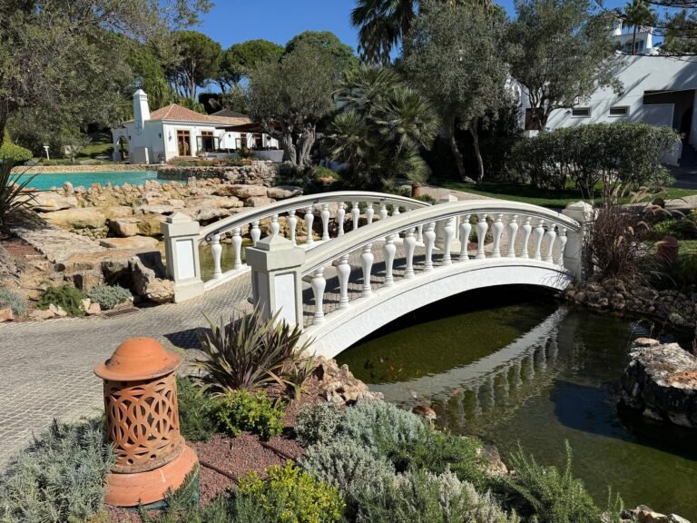 Ornamental white stone bridge over a garden pond at Vila Vita Parc