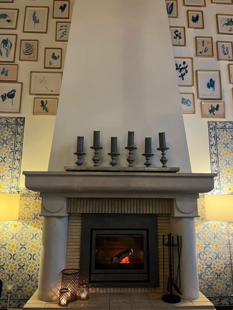 Fireplace and azulejo tiles in a Vila Vita Parc lounge with botanical prints