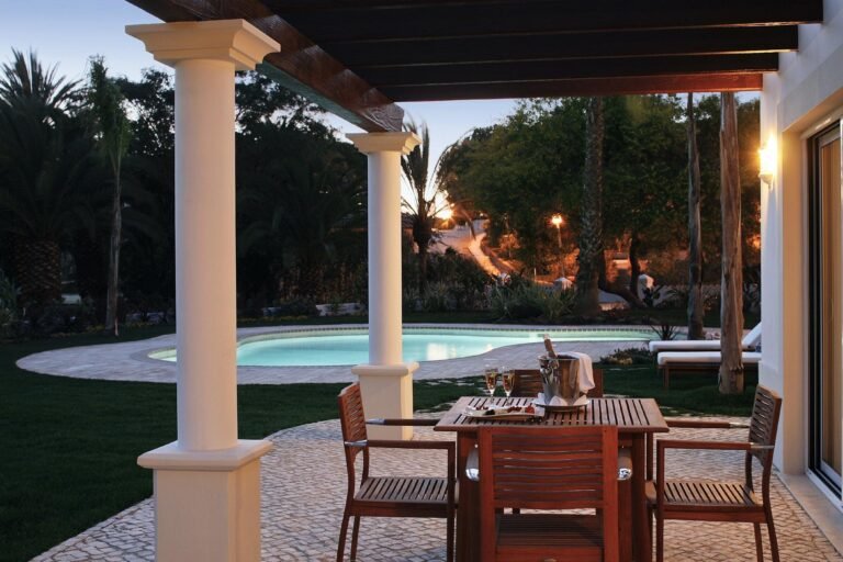 Whitewashed terrace of Vila Vita Parc with a private pool and Atlantic view at dusk