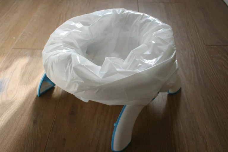 OXO Tot 2-in-1 Go Travel Potty unfolded in freestanding mode with its drawstring travel bag beside it