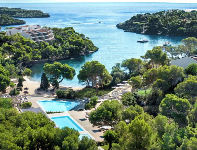 Aerial view of the Beach Club, swimming pool and turquoise cove at Ikos Porto Petro