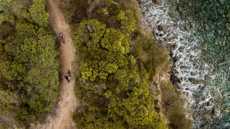 Aerial view of two cyclists on a coastal trail near Six Senses La Sagesse, Grenada