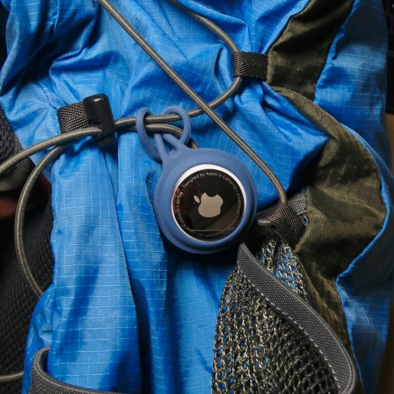 Apple AirTag attached to a backpack strap via keychain loop