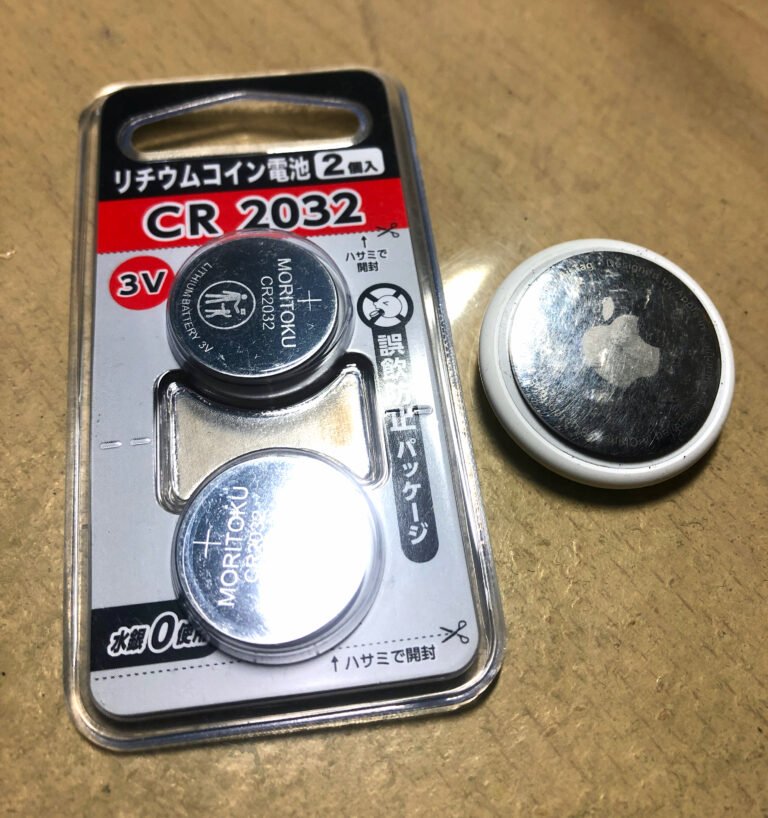 CR2032 3V button cell batteries next to an Apple AirTag