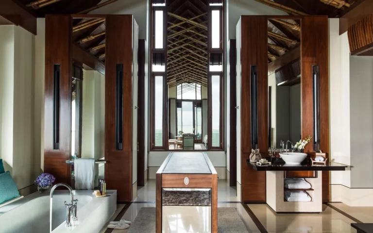 Open-air water villa bathroom at One&Only Reethi Rah with freestanding soaking tub above the lagoon