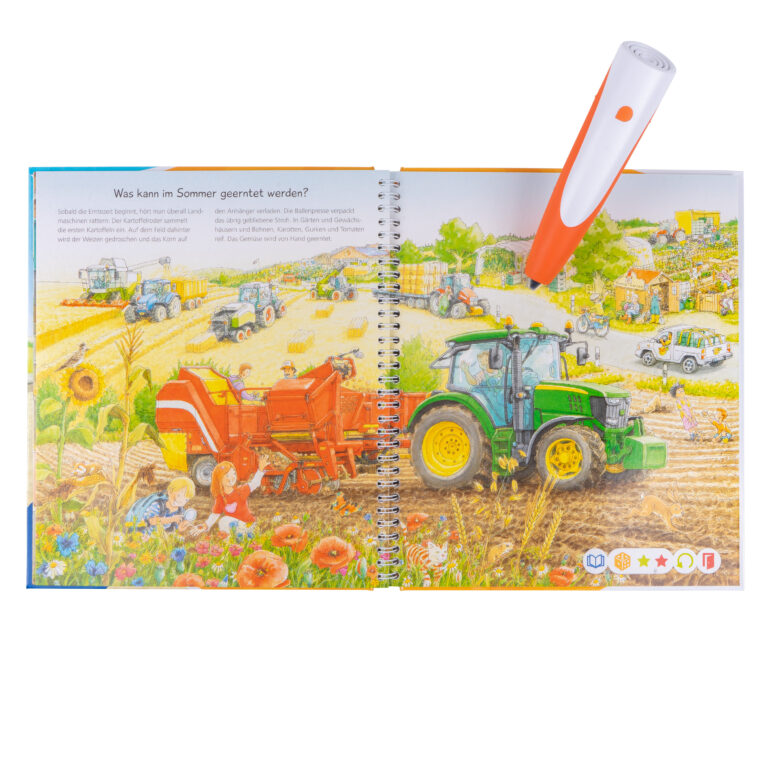 tiptoi pen resting on open farm book spread showing harvest scene with tractor, white studio background