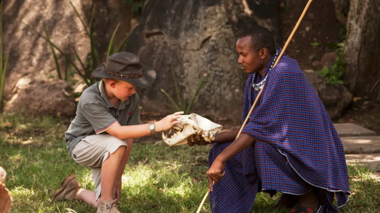 Young guest examining an animal skull with a Maasai guide at the Discovery Centre