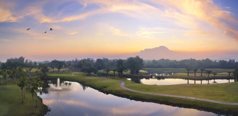 Golf course at Shangri-La Rasa Ria at sunset with sea view behind the fairway