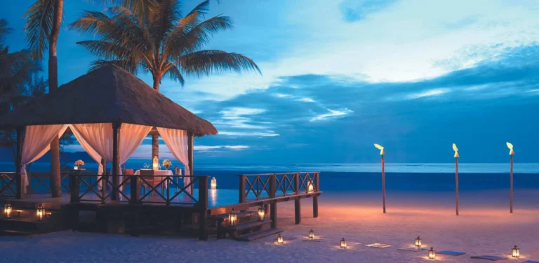 Beach gazebo at Shangri-La Rasa Ria at sunset with golden light over the South China Sea