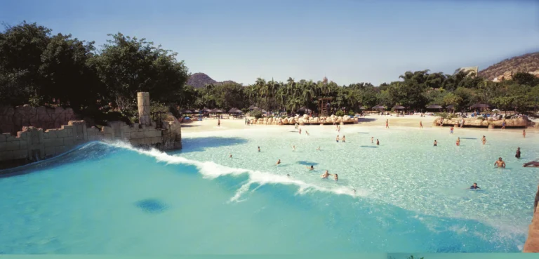 Families swimming in the Roaring Lagoon wave pool beside the man-made beach