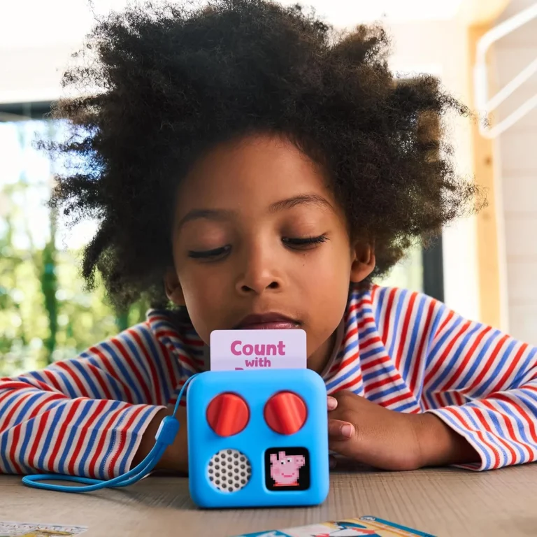 Child choosing a Yoto card for a Yoto Mini in a blue Adventure Jacket