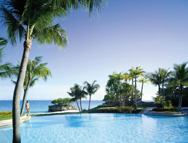 A wide freeform swimming pool bordered by palm trees at Shangri-La Mactan, Cebu
