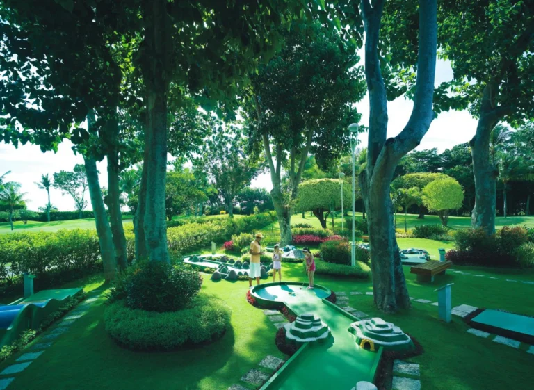 A family playing mini-golf on the resort's garden course at Shangri-La Mactan, Cebu