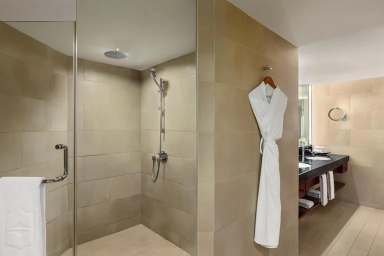 A modern walk-in shower and bathroom vanity in a guest room at Shangri-La Mactan, Cebu