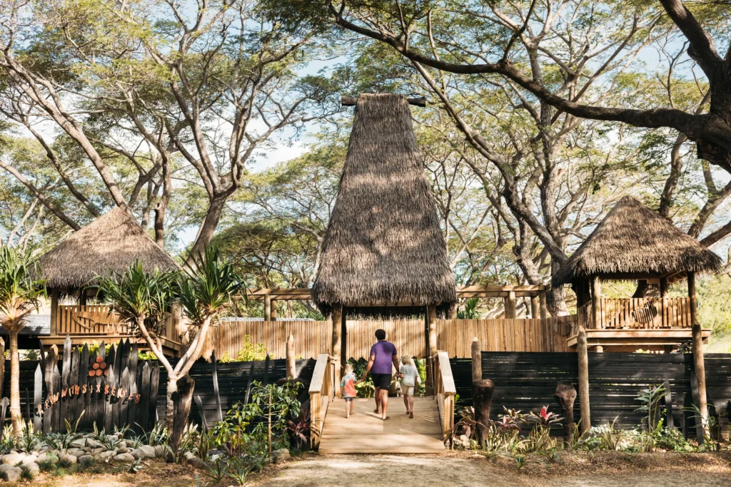 Father walking two children through the Grow With Six Senses kids club entrance at Six Senses Fiji
