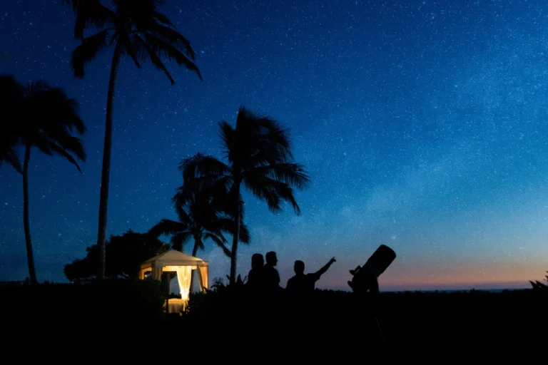Private stargazing session on the Ko Olina resort grounds at night — silhouetted guests with telescope under a star-filled Oahu sky