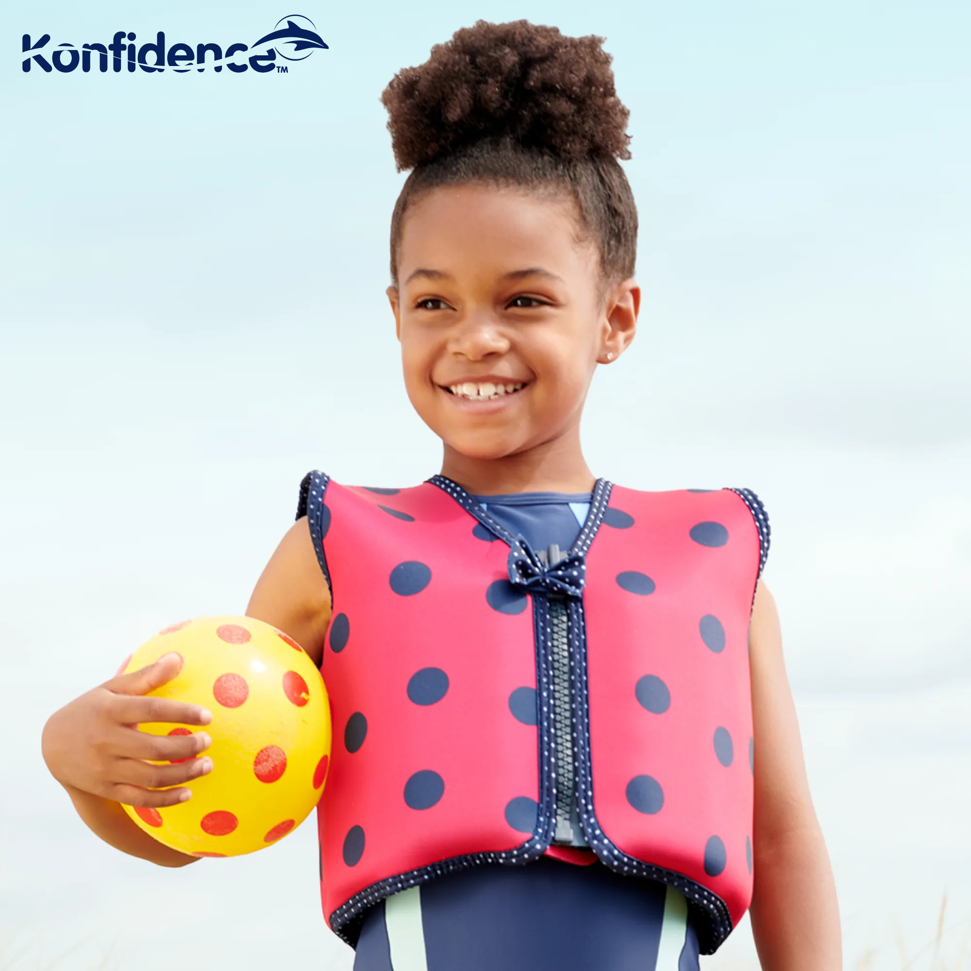 Young child swimming independently in a clear hotel pool wearing the Konfidence Original Jacket buoyancy swim vest with yellow back panel visible