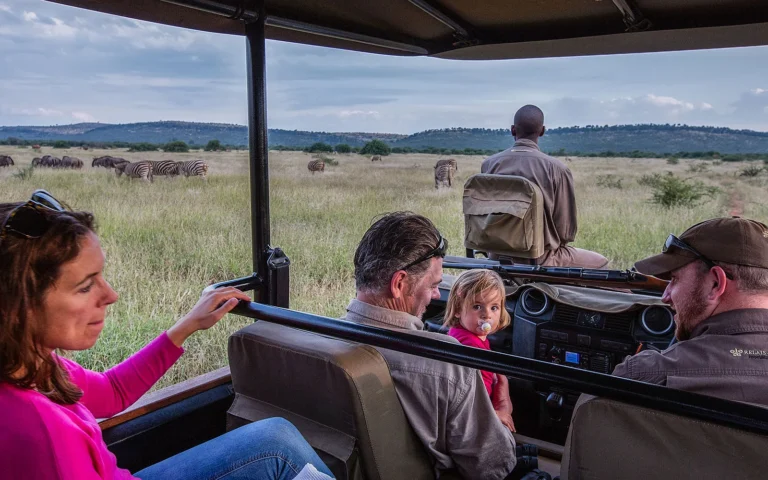 Family with a young child watching zebras from a private safari vehicle at Morukuru Family Madikwe