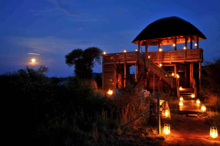 Morukuru safari hide lit by lanterns beneath the full moon in Madikwe Game Reserve
