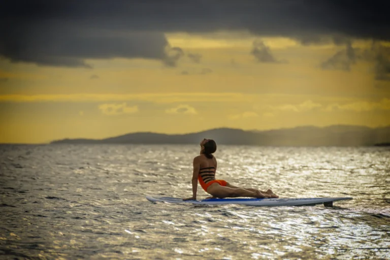 Stand-up paddleboard yoga on calm Pacific waters at Nanuku Resort Fiji