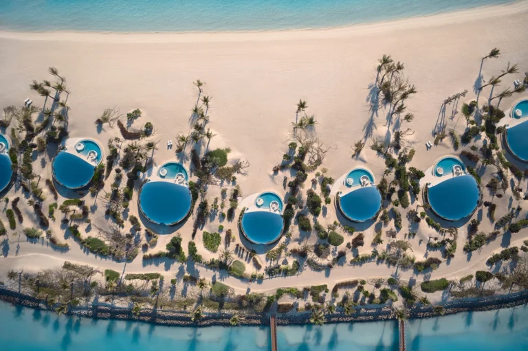 Drone aerial panorama of Shebara Resort showing full island layout and overwater villa string