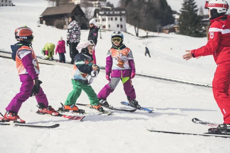 Children in a ski lesson group near Ortisei, with an instructor