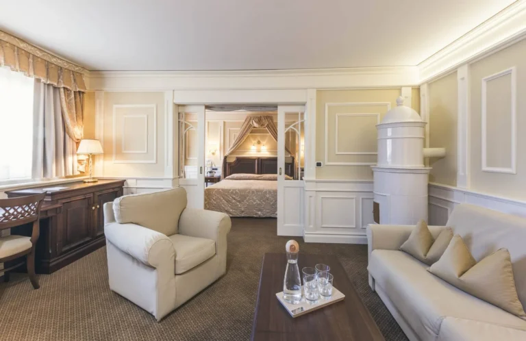 Suite living room and bedroom at Cavallino Bianco, with a traditional Tyrolean majolica stove