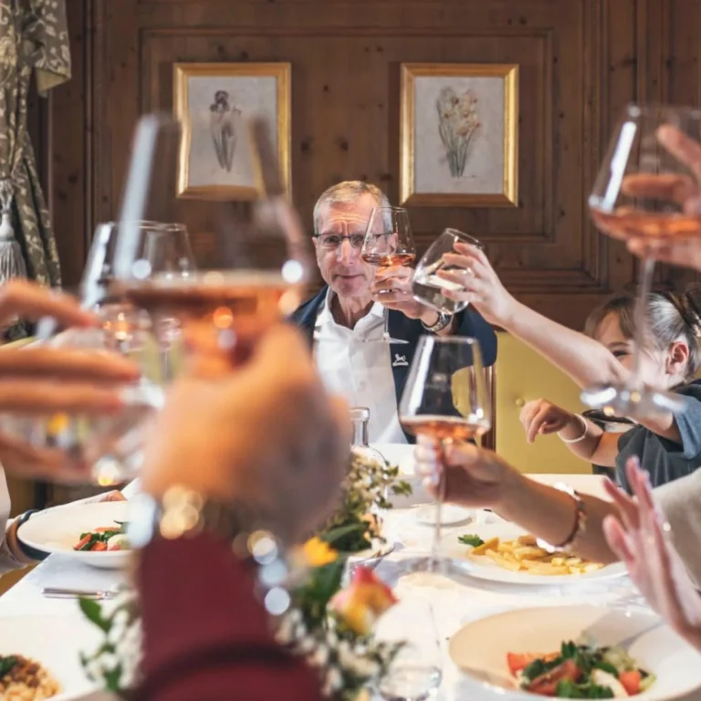 Family and guests raising a toast together at dinner, Cavallino Bianco