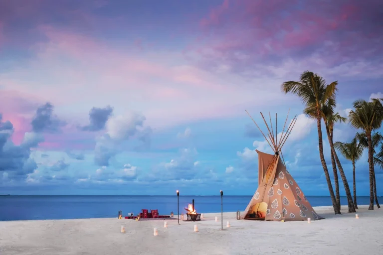 Private dining teepee on the beach at One&Only Le Saint Géran — candlelit table under white canvas, beach and sea backdrop