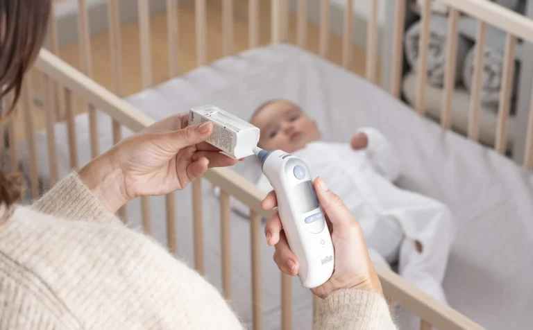 Parent taking child's temperature with Braun ThermoScan 7 IRT6520 ear thermometer