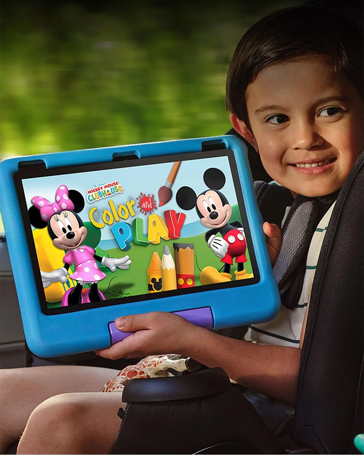 Young child using Amazon Fire HD 10 Kids tablet propped on kickstand handle at a hotel table