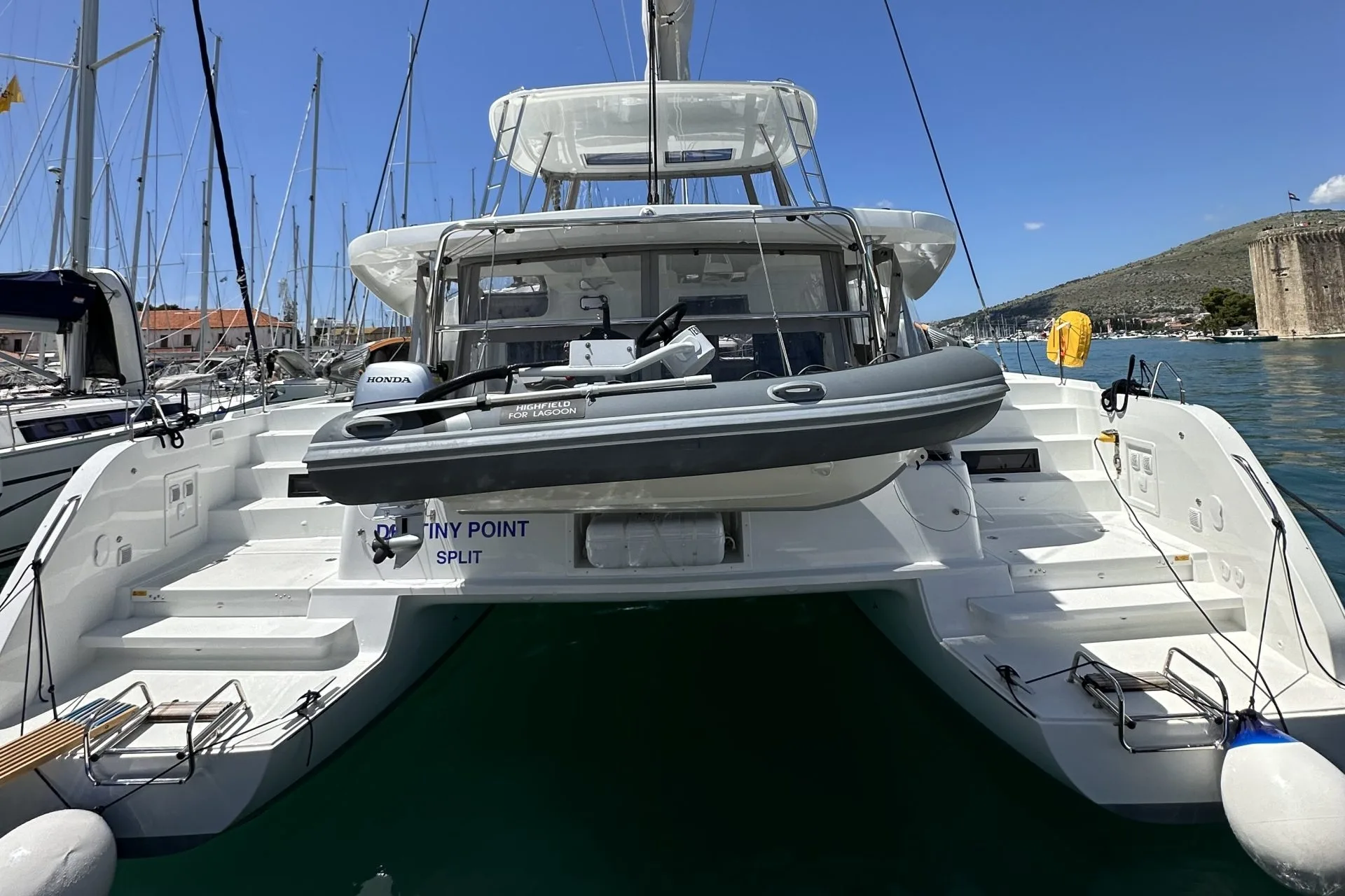 Destiny Point, a 2024 Lagoon 46 Fly, moored stern-to at ACI Marina Trogir with the Kamerlengo fortress behind